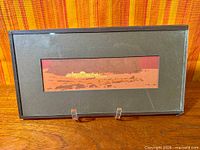 Frontal view of framed artwork showing full piece and frame