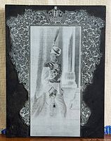 Front view showing portrait, ornate metal frame and crown motif