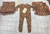 Onesie centered between two matching blankets on flat surface