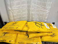 Stack of eight sealed yellow polybags containing socks