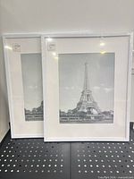 Two sealed white picture frames standing side by side front view