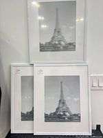 Front view showing three sealed white frames with sample Eiffel Tower print