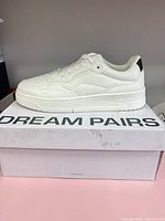 Side profile of white Dream Pairs sneaker on box