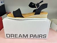 Side view of right sandal on box showing entire design and Dream Pairs branding