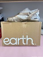 Side view of sandal on branded box