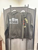 Front view of both hoodies hanging to show overall design and size