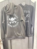Front view of both hoodies on hangers