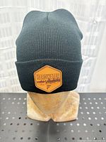 Front view showing Hardwater logo patch on black knit toque