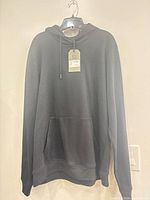 Front view of dark grey Stormtech hoodie with tags attached