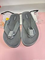 Top view of pair grey NORTIV 8 flip flops in plastic wrap
