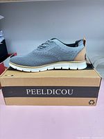 Side view of right sneaker on top of branded box