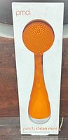 Front view of boxed orange PMD Clean Mini device