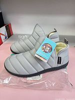 Pair of light grey RockDove puffer booties with tag attached, shown side view