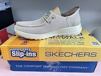 Side view of shoe on top of original box showing design and branding