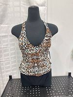 Front view of leopard print halter tankini top on mannequin with black bottoms