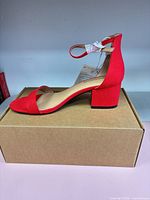 Left side view of red block heel sandal on top of box