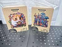 Front view of both boxed puzzles showing artwork, size designations and brand