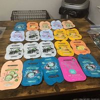 Tabletop view of 20 Freeman mask sachets arranged in rows with zip bag of eye patches at side