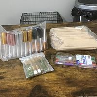 overall lot showing mascara tubes pack, lip-gloss tubes pack, wood sticks, blister pack cosmetic tubes