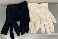 Two pairs of gloves, one navy crochet, one white fabric