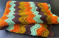 Folded afghan showing multicolour chevron pattern