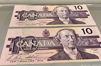 Obverse of both banknotes showing portrait, denomination and partial serial numbers