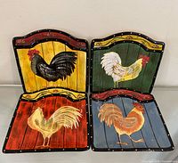 Four plates laid out to show individual rooster designs and colour backgrounds