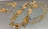 Full view of necklace and matching earrings laid flat