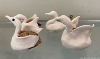 Three walnut-shell swan figurines front view
