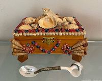 Top view of shell-covered jewelry box with spoon in front