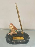 Front view of porcelain sparrow pen holder on marble base
