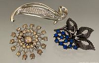 All three brooches displayed together