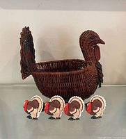 Front view of wicker turkey basket with four ceramic napkin holders