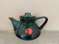 Front view of teapot showing glaze and foil label