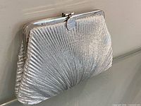 Front view of silver pleated evening clutch showing entire exterior and clasp