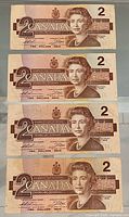 Fronts of four $2 notes stacked