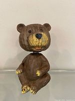 Full view of wooden bobblehead bear seated, showing overall form and size