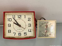 Front view of both clocks side by side