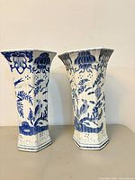 Front view of both matching blue and white ceramic vases standing upright