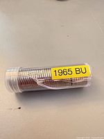 Side view of tube showing stacked 1965 coins and crack in tube