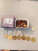 Overall lot: tub of pennies, box of coin mounts, row of commemorative coins, single silver-tone coin