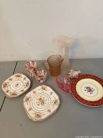 Overall view of plates, tumblers, depression glass pieces and vase