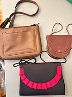 three handbags arranged together showing relative sizes and designs