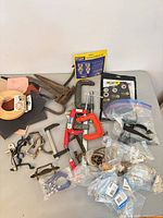 Overall view of assorted clamps, packaged hardware, sandpaper, veneer edge banding