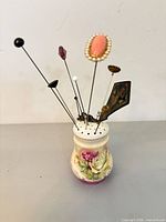 Porcelain floral holder with hat pins displayed