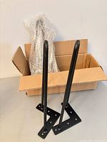 Two black hairpin legs standing with mounting plates visible