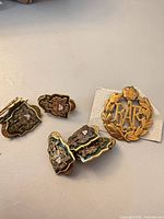 Group shot of five Canadian collar badges and one RAF cap badge