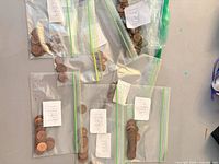 Overview of seven bags of Canadian pennies with year labels