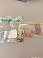 Two bags of pennies on table