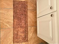 Full view of carved wood panel on tiled floor